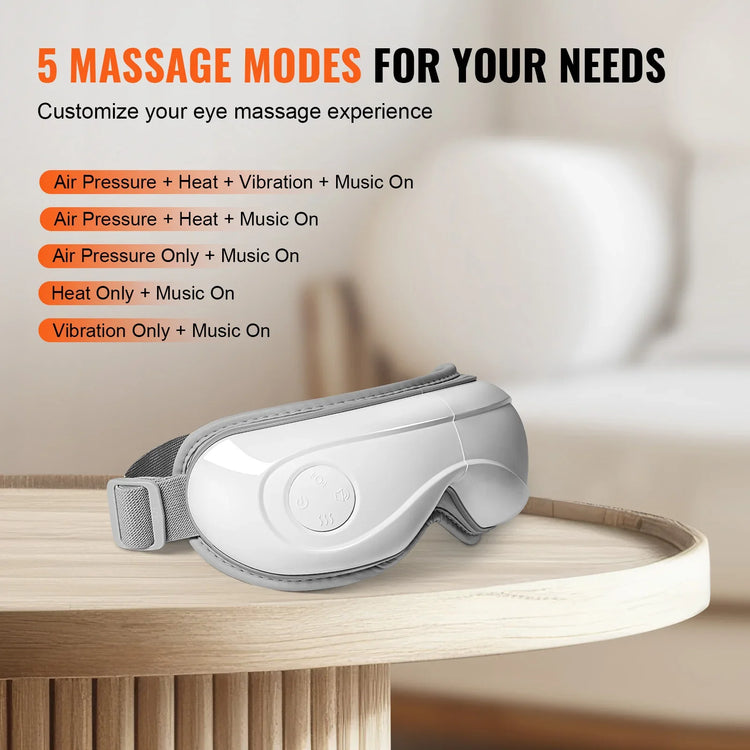 White adjustable eye massager with soft gray strap on a wooden table, modern home setting.