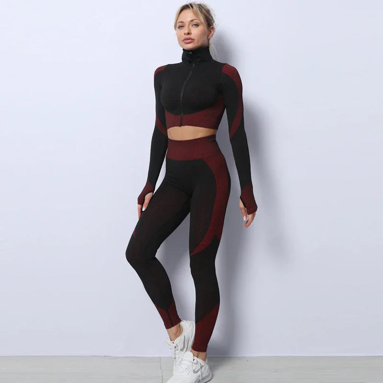 Woman wearing black and burgundy seamless two-piece athleisure set, slim fit, high waist leggings, long sleeve crop top.