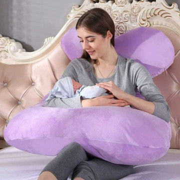 Woman in gray long-sleeve top with fitted style, holding baby on large lavender pillow
