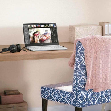Pink cable knit sweater draped on blue patterned chair, cozy streetwear style
