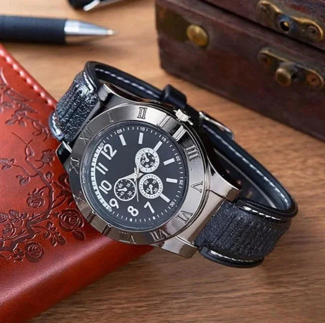 Black leather strap watch with silver case, Roman numerals, and chronograph dial on desk