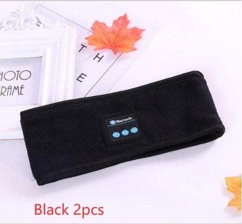 Black wireless Bluetooth headband made of soft fabric, rectangular shape, folded, athletic style.