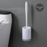 Minimalist wall-mounted gray toilet brush with sleek white holder next to toilet