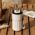 Matte white insulated water bottle with digital lid, strap handle, modern outdoor style