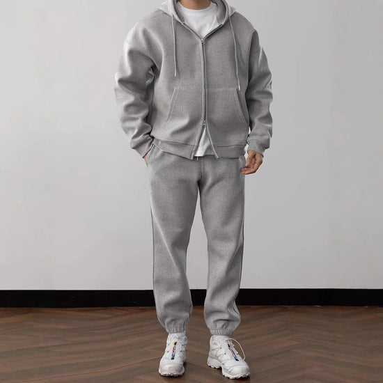 Man wearing gray fleece zip hoodie and jogger sweatpants set, relaxed fit, white sneakers