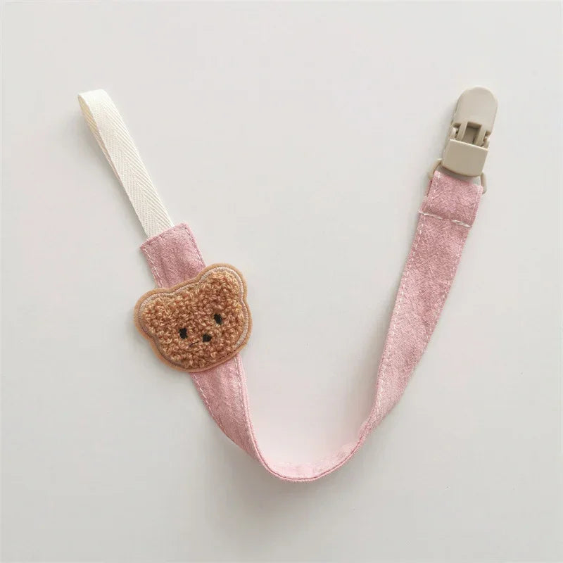 Pink fabric pacifier clip with plush bear face and plastic clasp, cute accessory for babies