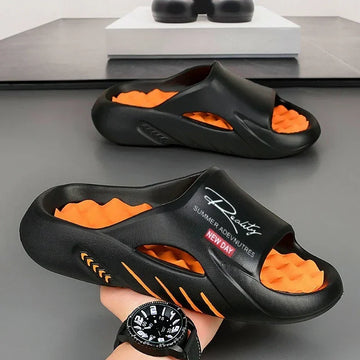 Black and orange chunky slide sandals with textured sole, open toe design, casual streetwear style.