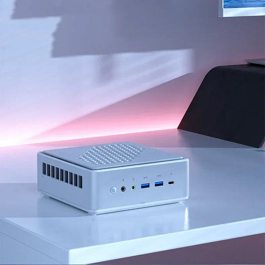 Sleek white desktop mini PC with vented design and multiple front ports on a modern workstation