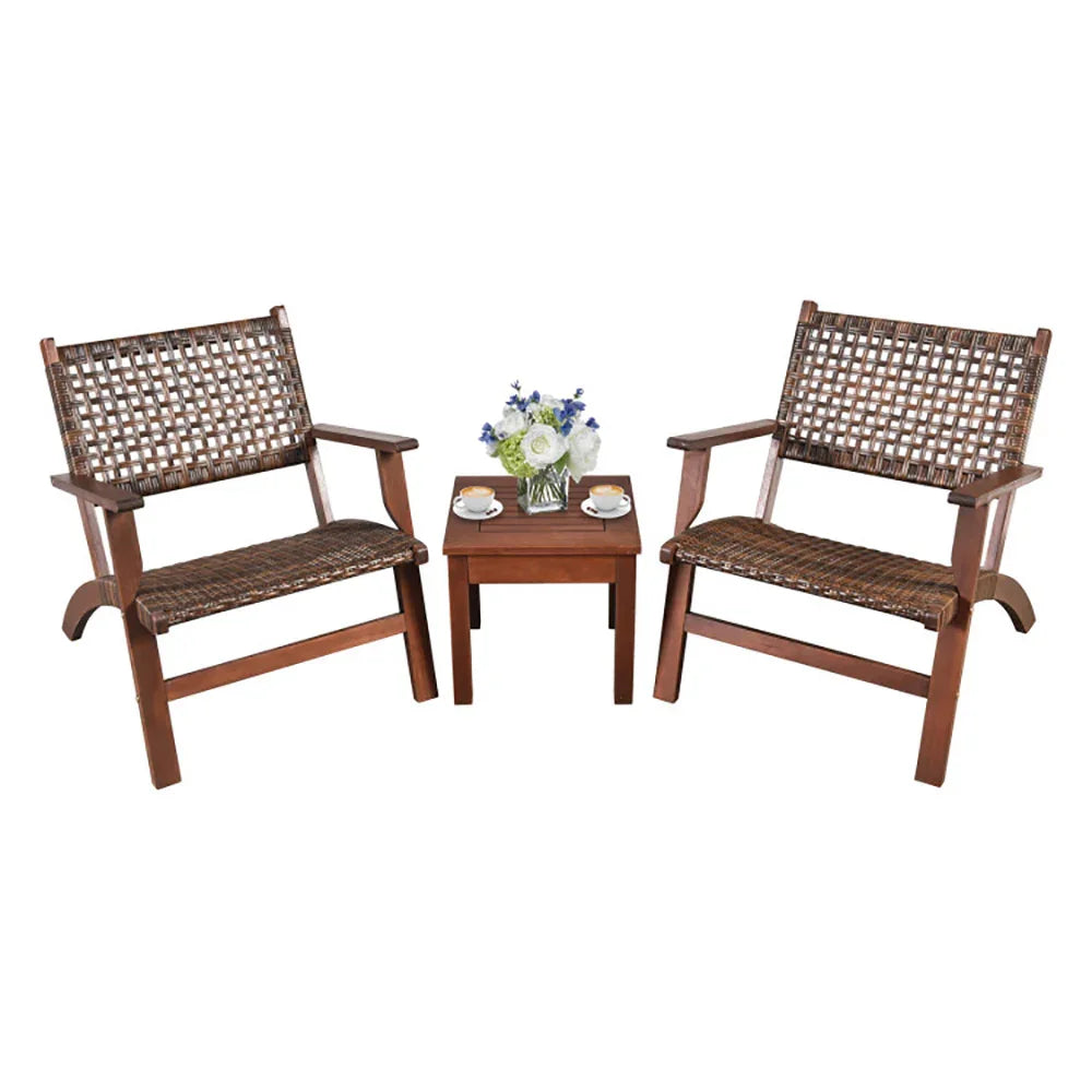 Two brown woven wooden armchairs with matching side table, coffee cups, and flower vase.
