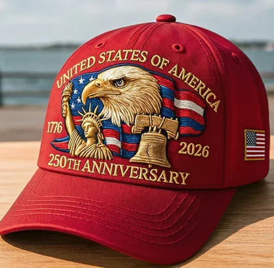 Red embroidered baseball cap featuring bald eagle, Statue of Liberty, Liberty Bell, and US flag