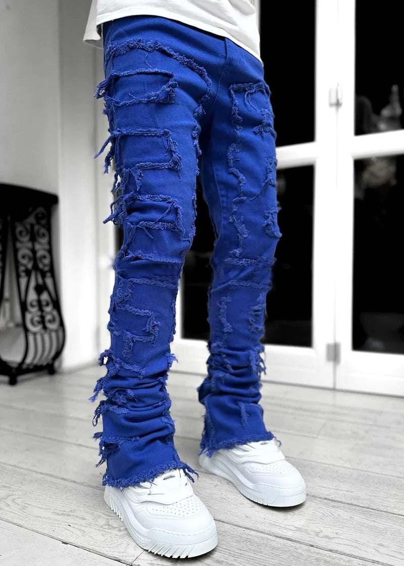 Blue distressed skinny jeans with heavy fraying, paired with chunky white sneakers