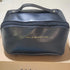 Black faux leather zippered clutch bag with top handle and gold text, rectangular shape