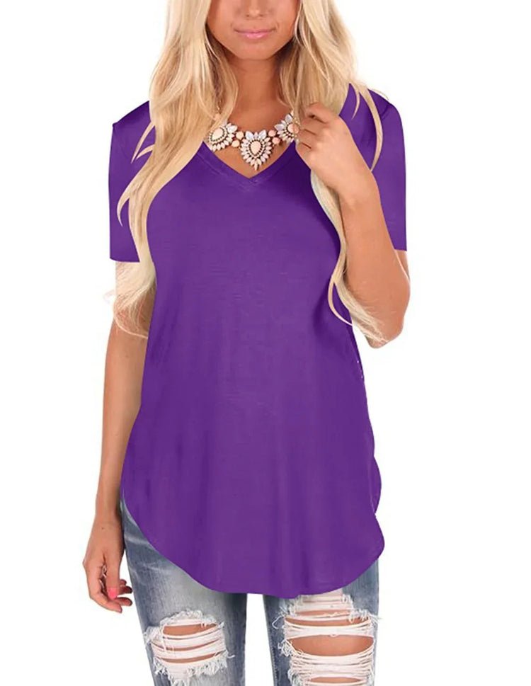 Woman wearing a loose-fit purple V-neck short sleeve top with distressed jeans