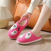 Pink fuzzy slippers with cute white ghost designs, cozy indoor footwear, relaxed fit