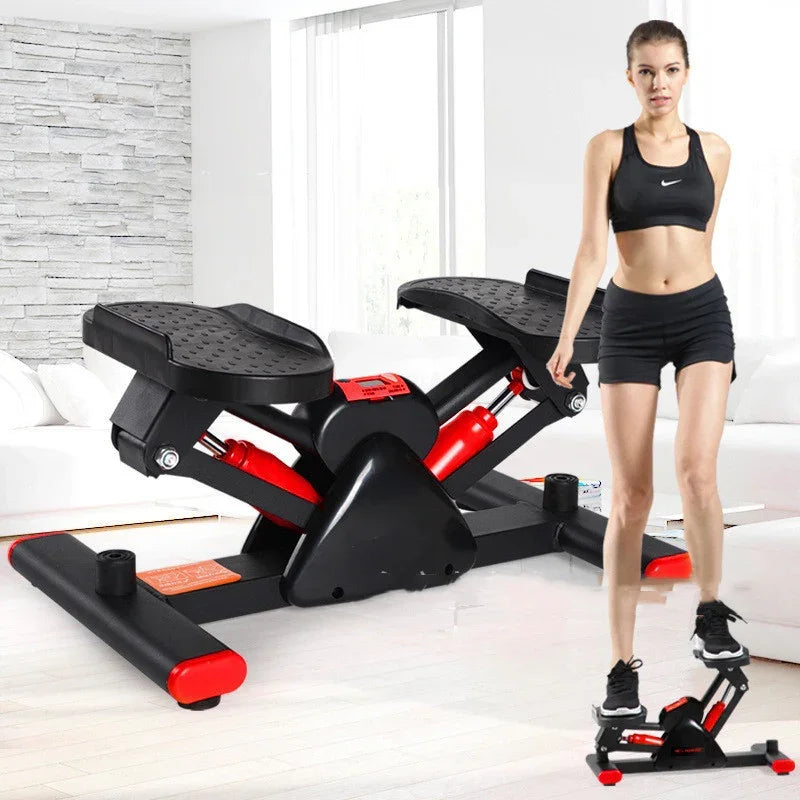 Woman in black sporty crop top and shorts using compact home stepper exercise machine