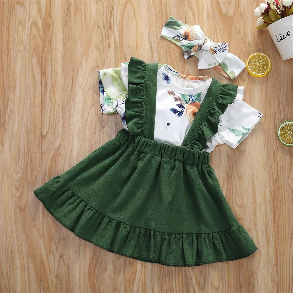 Green ruffle suspender skirt with floral short sleeve top and matching headband, cotton, toddler size.