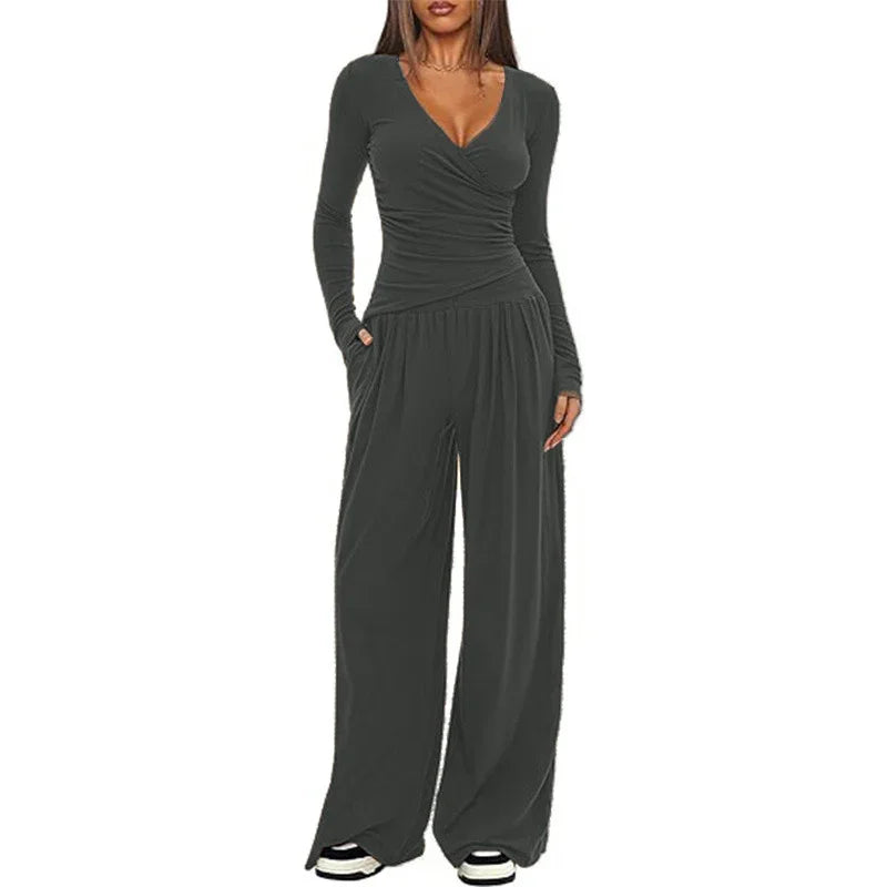 Woman wearing dark gray long sleeve wrap jumpsuit with wide leg pants and relaxed fit