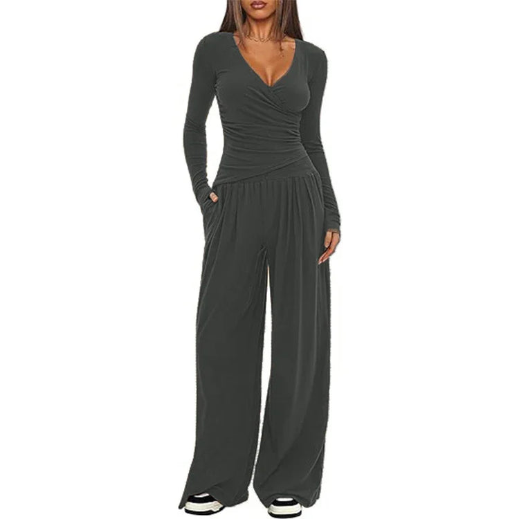 Woman wearing dark gray long sleeve wrap jumpsuit with wide leg pants and relaxed fit