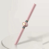 Pink and gold metallic facial roller massage tool with sleek, modern design on white surface