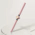 Pink and gold metallic facial roller massage tool with sleek, modern design on white surface