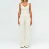Woman wearing fitted cream halter jumpsuit with flared legs, modern streetwear style