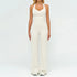Woman wearing fitted cream halter jumpsuit with flared legs, modern streetwear style