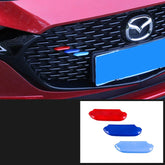 Red car front grille with red, dark blue, and light blue decorative clip-on trim accents.