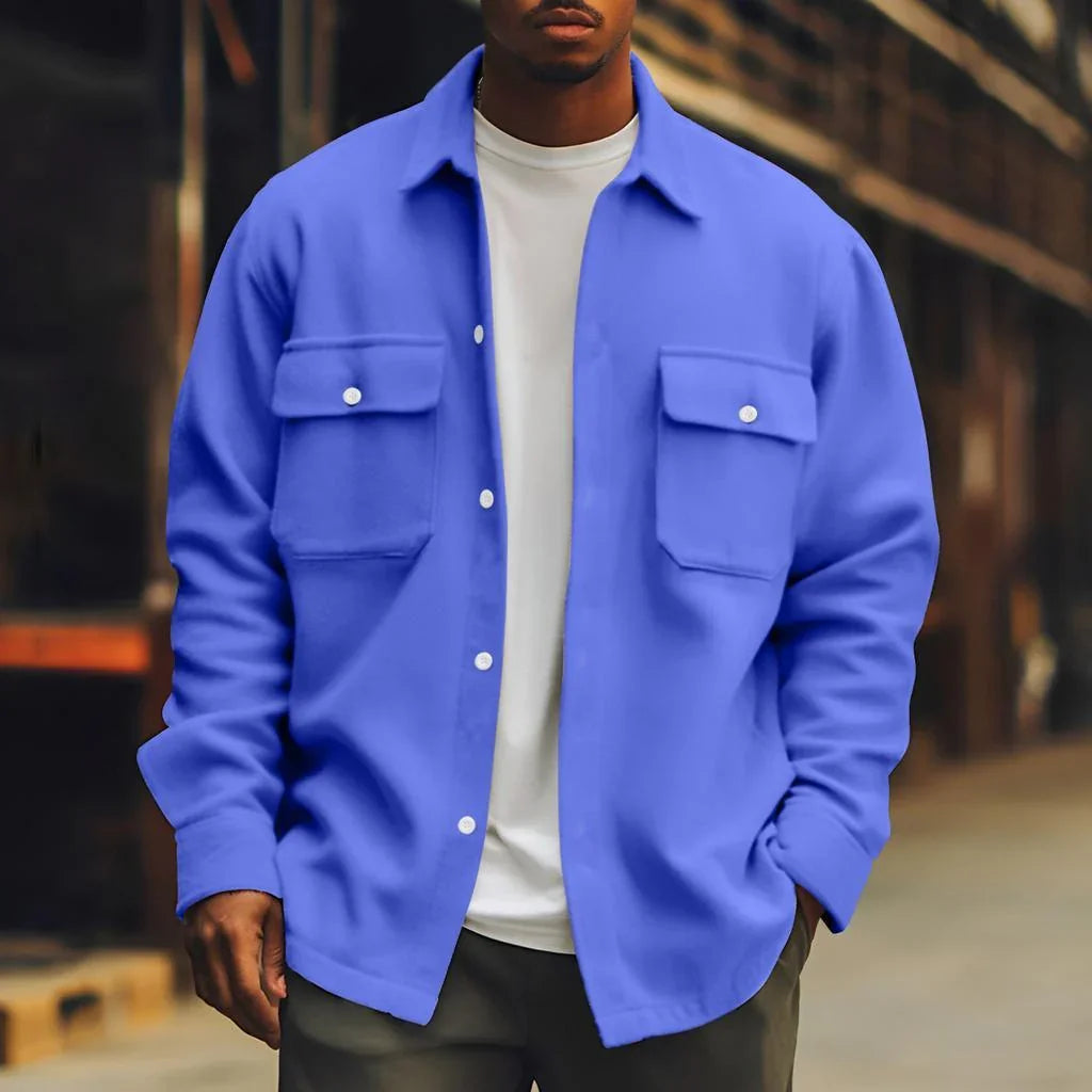 Man wearing a relaxed fit blue overshirt with snap buttons and flap pockets over a white tee