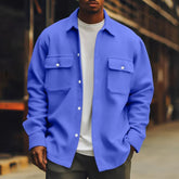 Man wearing a relaxed fit blue overshirt with snap buttons and flap pockets over a white tee