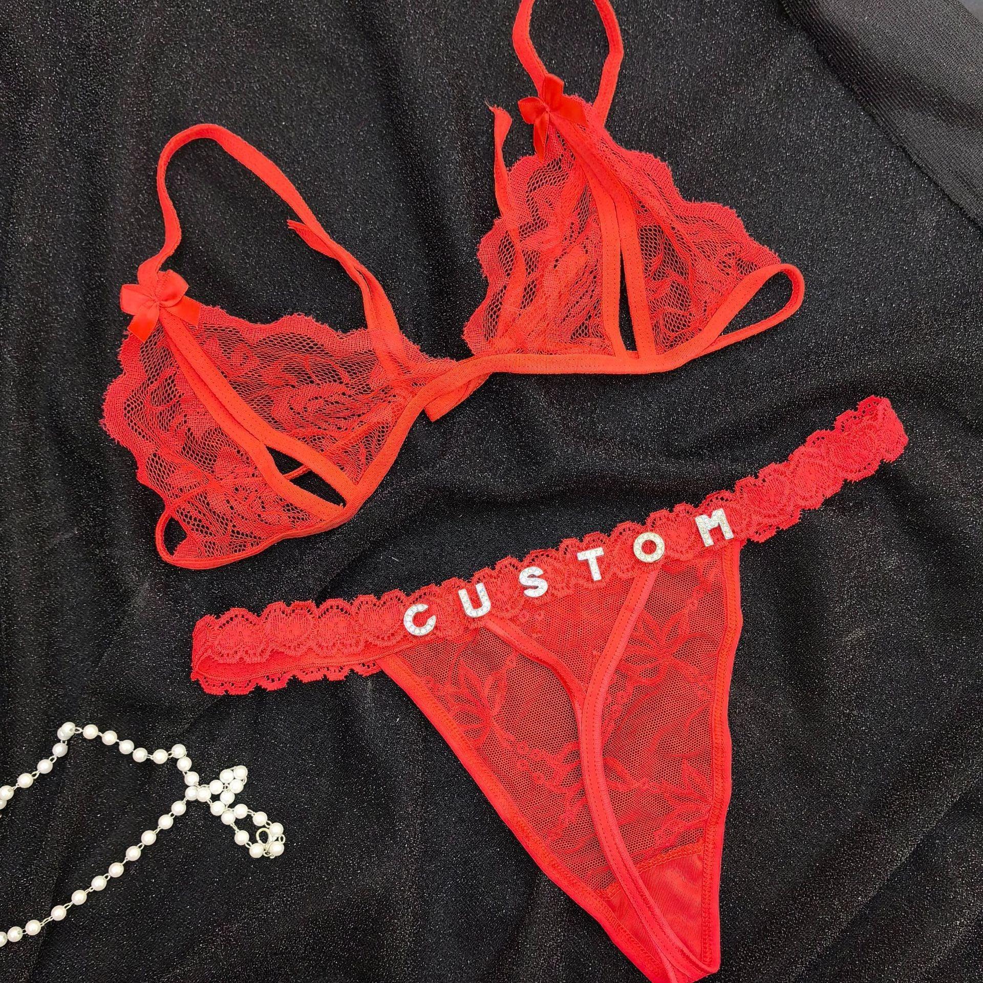 Red lace lingerie set with sheer bra, bows, and custom lettered thong on black fabric