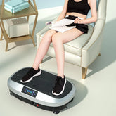 Woman in black crop top and shorts, relaxed fit, using vibration platform machine indoors