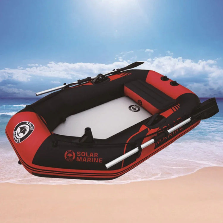 Red and black inflatable boat with oars on sandy beach, durable PVC material, spacious fit