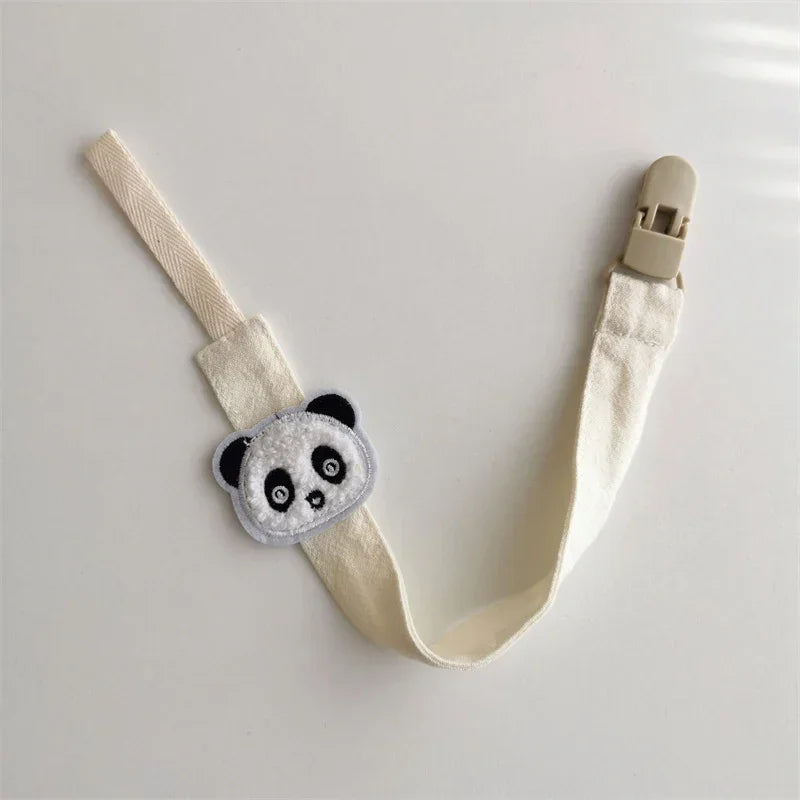 Cream fabric strap with plush panda face patch and plastic clip, minimalistic style
