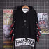 Black oversized streetwear hoodie with bold white graphic text and red lettering on sleeves
