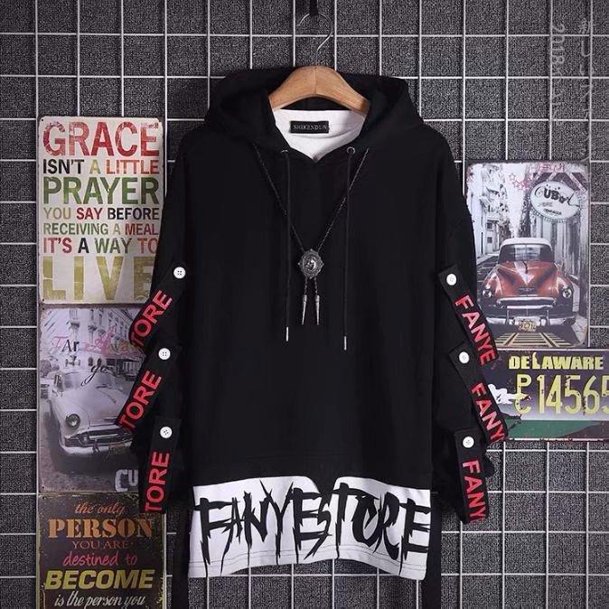 Black oversized streetwear hoodie with bold white graphic text and red lettering on sleeves
