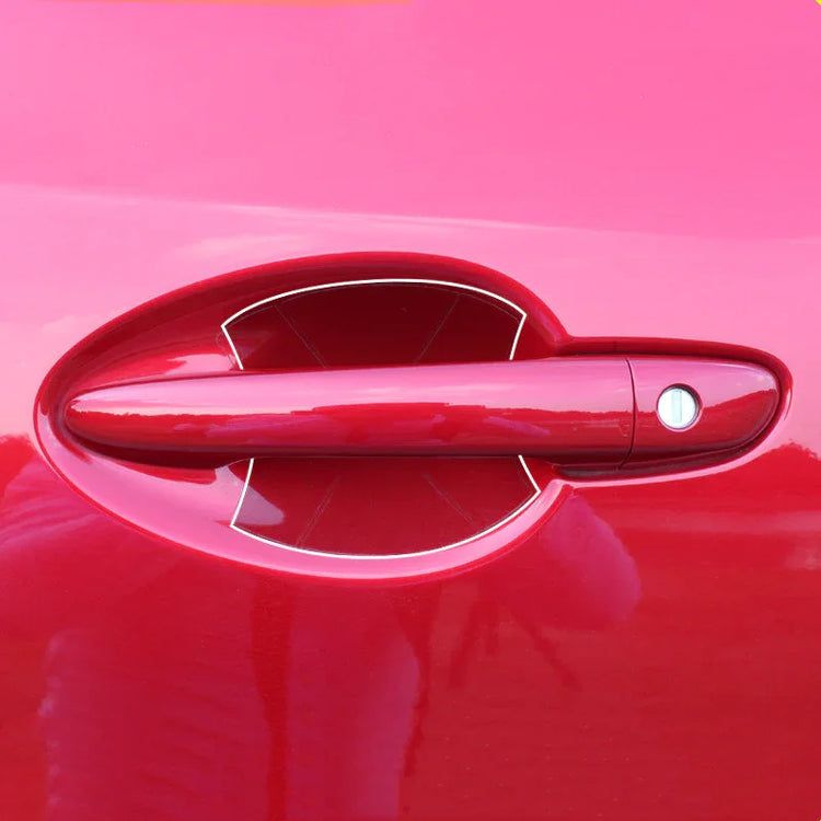 Close-up of a shiny red car door handle with smooth, glossy paint finish