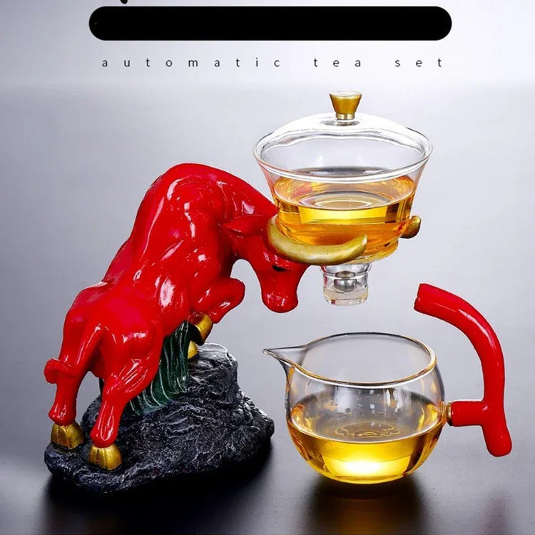 Modern glass automatic tea set with a red bull-shaped holder and golden-yellow tea