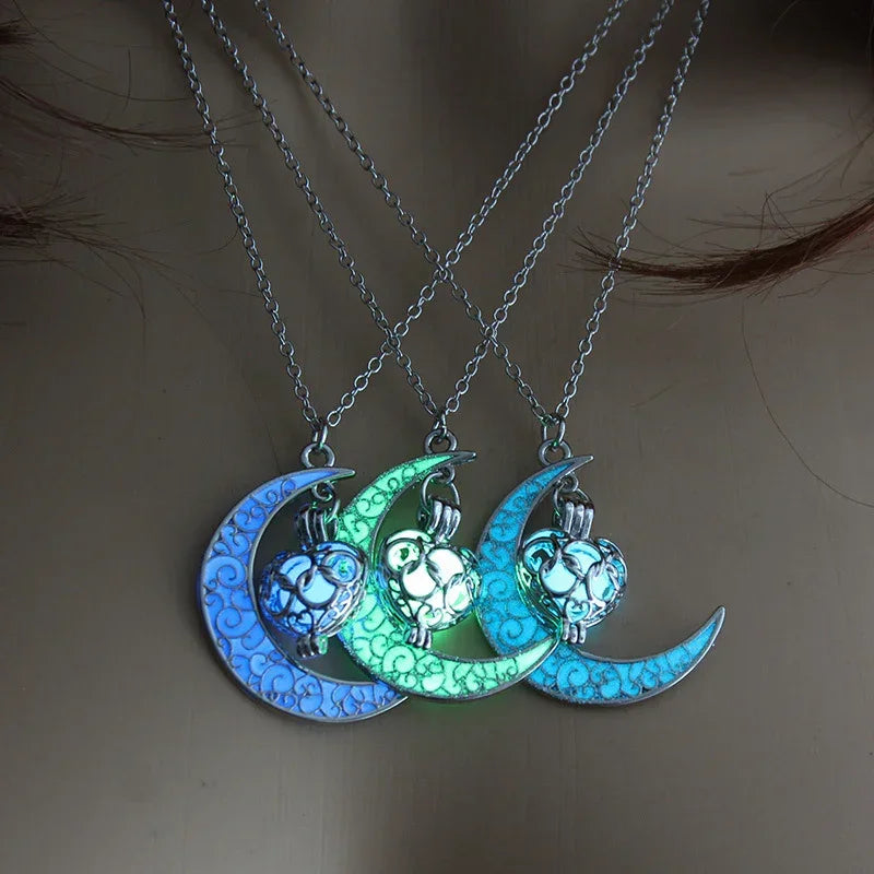 Three glowing crescent moon necklaces with owl pendants in blue and green, worn on chest