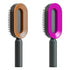 Two oval hairbrushes with unique hollow centers, one brown and one pink, black handles
