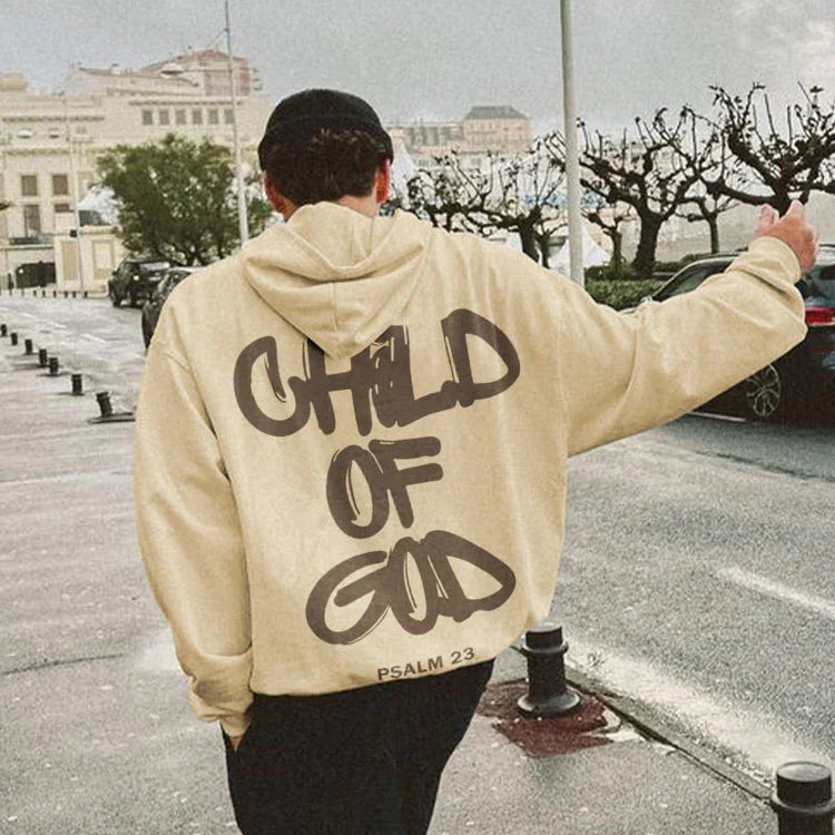 Beige oversized streetwear hoodie with bold graffiti text, relaxed fit, outdoor urban setting