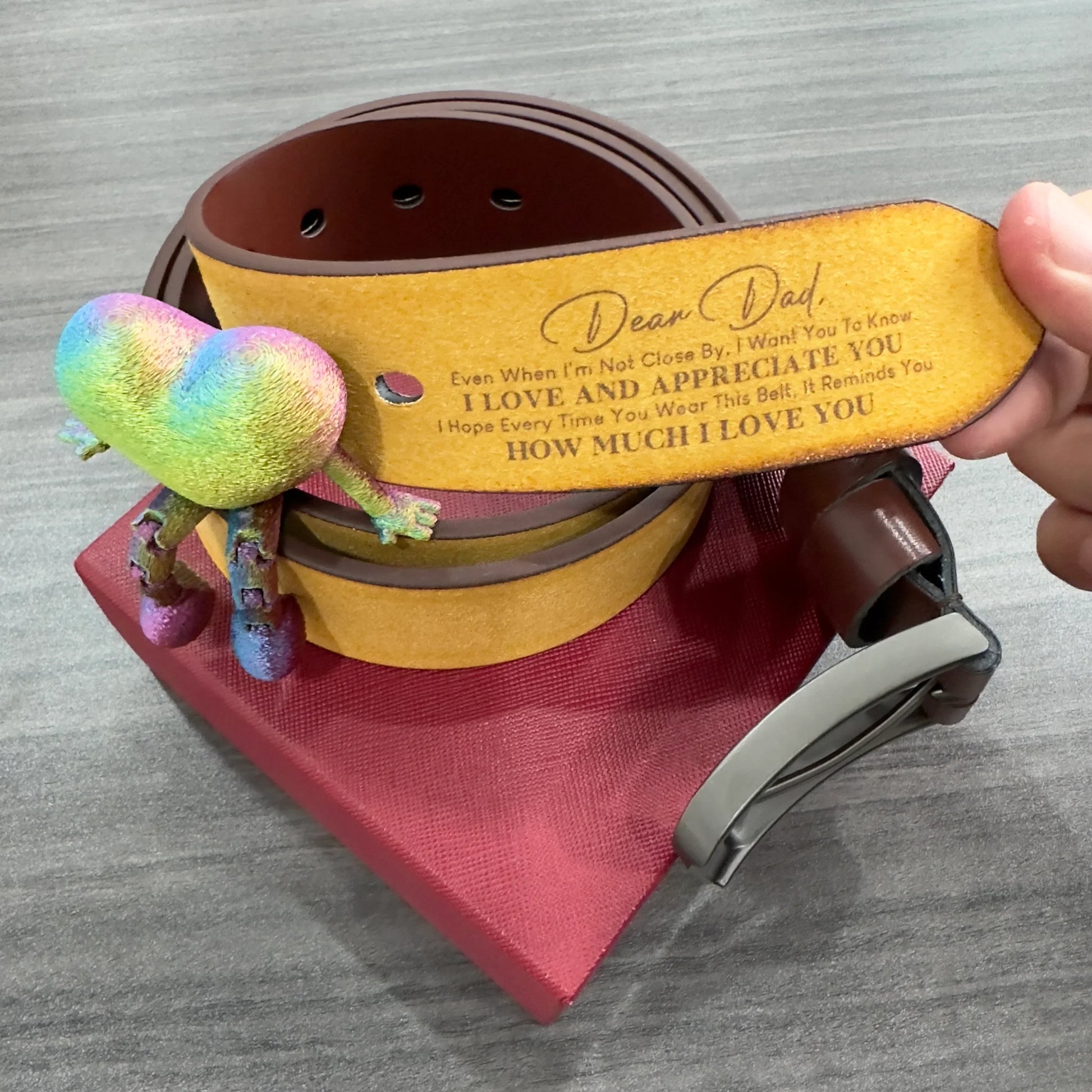Brown leather belt with engraved heartfelt message, silver buckle, displayed on red box