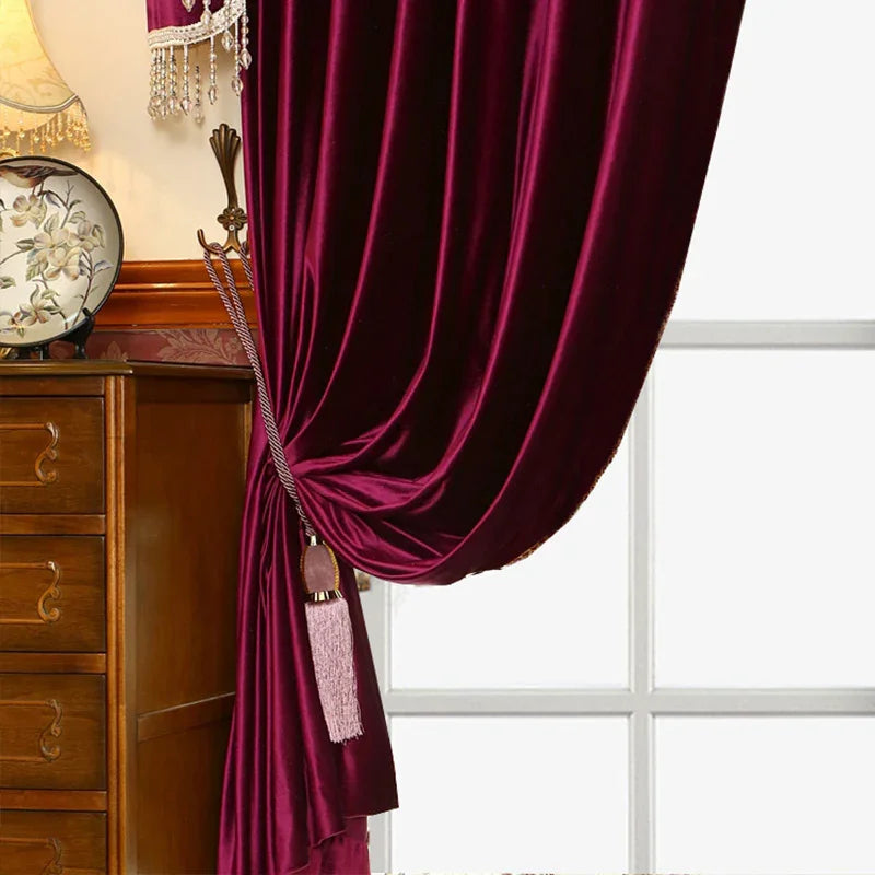 Plush burgundy velvet curtain with decorative tassel, draped in a classic interior setting