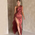Woman wearing a satin one-shoulder rose gold evening gown with high slit, slim fit
