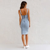 Woman wearing light blue denim bodycon dress with thick straps and zip back closure