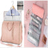 Light pink travel garment bag with gold zippers, adjustable strap, includes mesh toiletry organizer