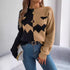 Two-tone knit sweater with abstract face design, relaxed fit, paired with blue jeans