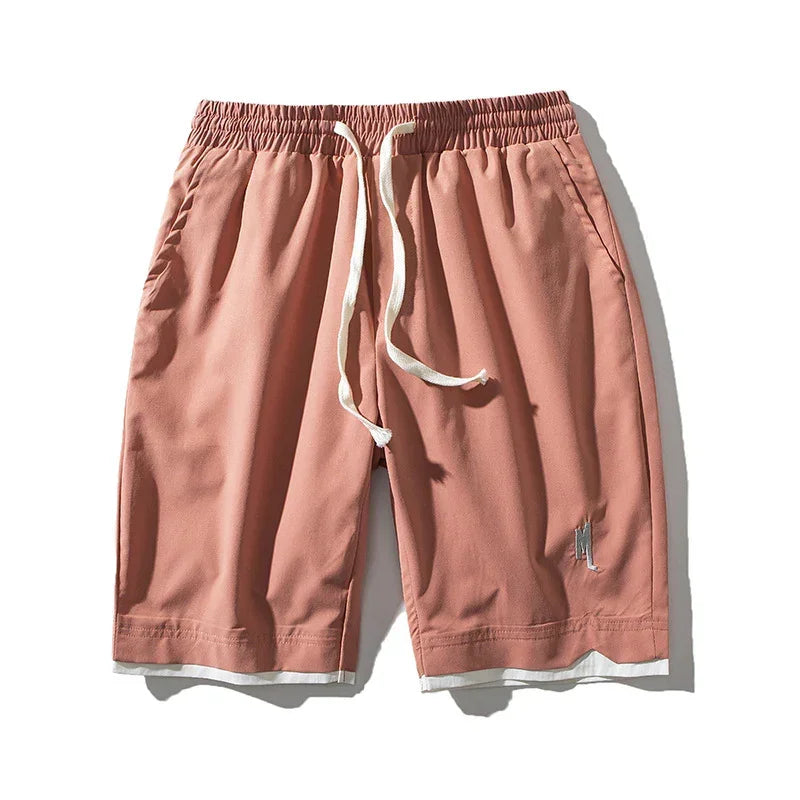 Men's loose fit pink drawstring shorts with elastic waistband and side pockets