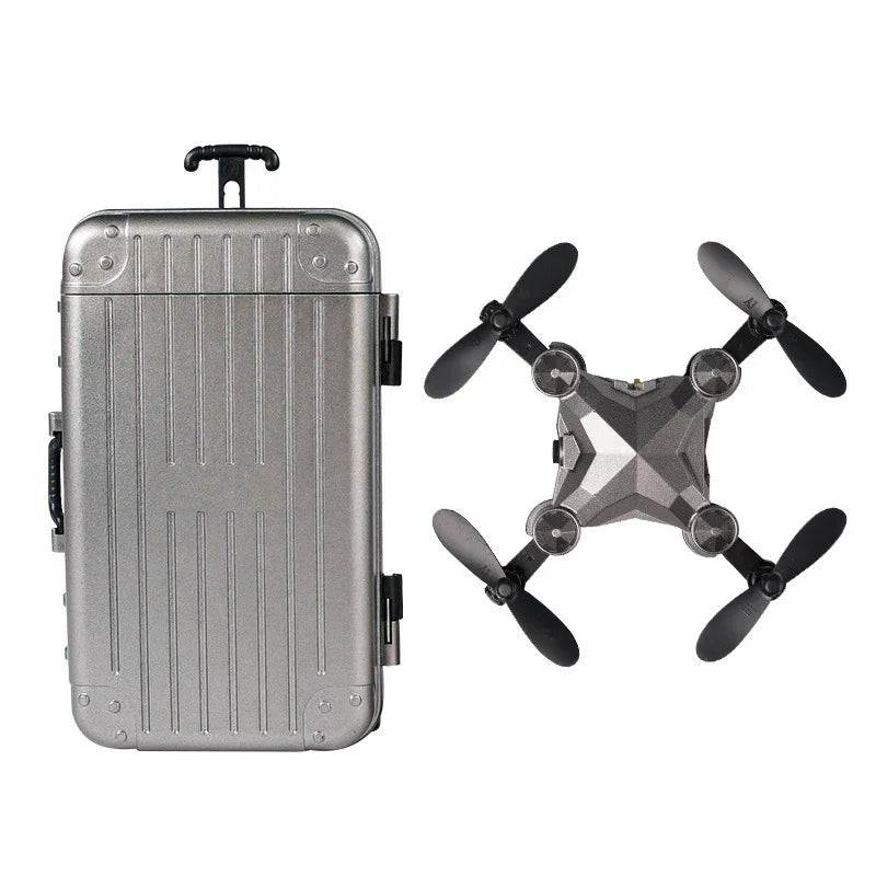 Metallic gray hard-shell suitcase and compact foldable drone with black propellers