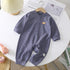 Long-sleeve purple striped baby romper with snap buttons and a small bear patch, cotton material, loose fit