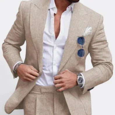 Slim fit beige suit with white dress shirt, linen texture, and blue sunglasses accent